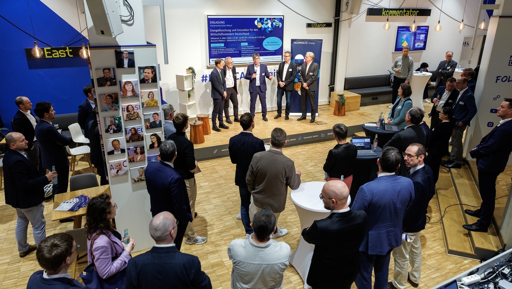Business event with speakers on a stage, attendees mingling in a modern expo hall.
